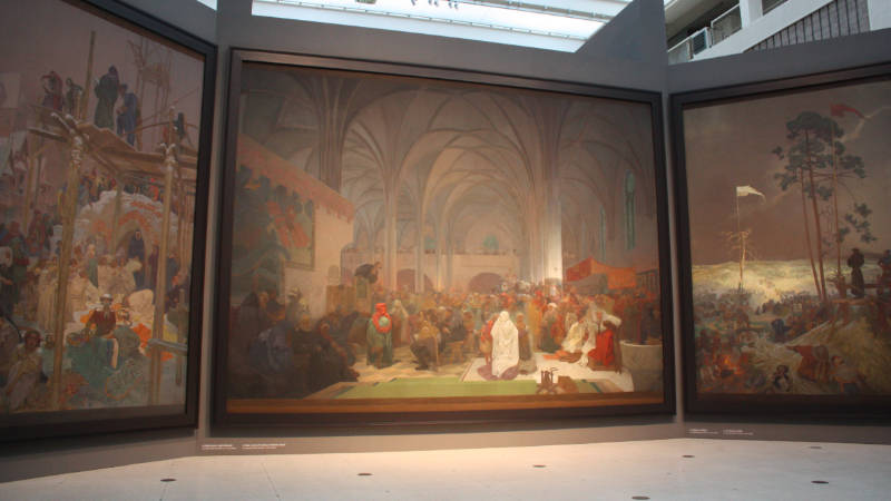 Husitský triptych Kouzlo slova z cyklu Slovanská epopej od Alfonse Muchy vystavené ve Veletržním paláci Národní galerie v Praze v roce 2012.