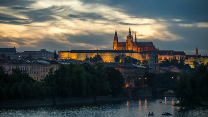 Noční panorama Prahy s pražským hradem u řeky
